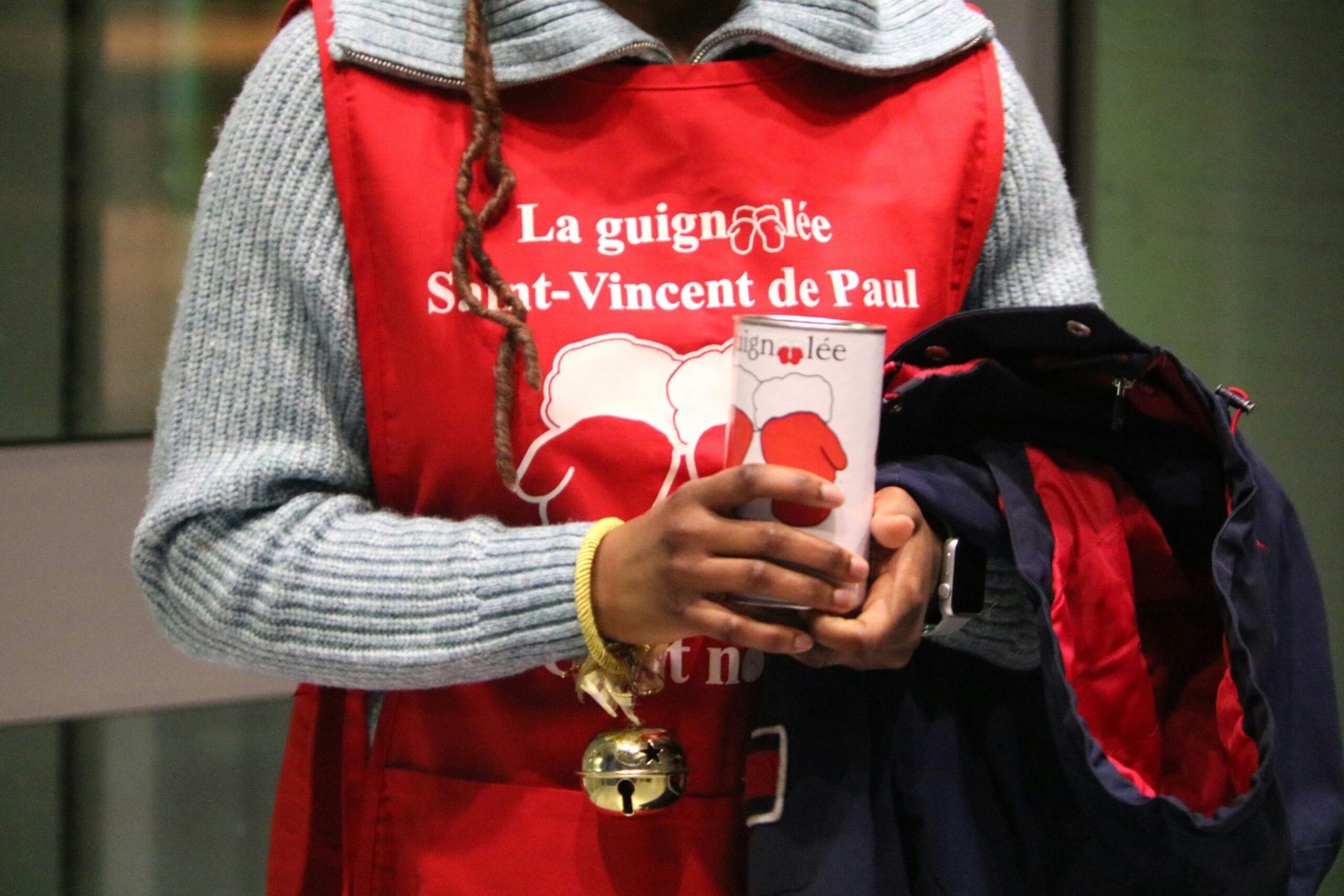 a woman in a red vest holding a cup
